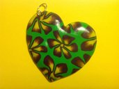 Ciondolo in fimo a forma di cuore su base verde con fiori nei toni del giallo e viola