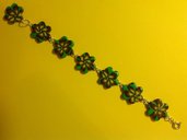 Bracciale in fimo con perle a forma di fiore su base verde con fiori nei toni del giallo e viola