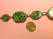 Bracciale in fimo con perle a forma di ovale su base verde con fiori e rose nei toni del giallo e viola