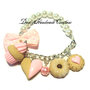 Bracciale con perle bianche, fiocco rosa a pois bianchi in tessuto e cupcake e biscotti in fimo e cernit rosa