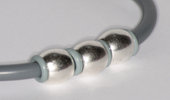Bracciale in caucciu' grigio e tre elementi in metallo
