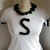 T-Shirt personalizzate/Personalized white cotton T-shirt with black hand-knitted applications- flowers and letter S.