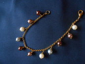 bracciale fatto a mano con catene dorate,  perle marroni, bianche e grige,ideale come idea regalo.