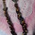Collana con fili di perle colorate intrecciate e inserto metallico a forma di cuore