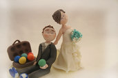 wedding cake topper con sposa che trascina lo sposo amante del gioco delle bocce