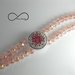 Bracciale a filo doppio con pietre sfaccettate rosa e inserto in metallo con strass