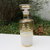 Bottiglia liquore in vetro con decori a righe color oro