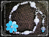 Bracciale con perle e connettore fiore smaltato azzurro con strass centrale.