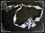 Bracciale con perle e connettore farfalla smaltata bianca e nera e strass.