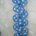 Braccialetto con perle shell inserite nel tubolare a rete azzurra.