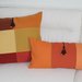 coppia di cuscini con nappine marroni in gradazione color arancio