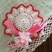 Cappellino fatto ad uncinetto con nastrino rosa con fiore decorativo