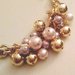 Bracciale catena d'oro e perle di varie dimensioni e colori.