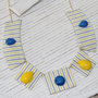 Collana a segmenti, in stoffa gialla e azzurra a righe con pietre cabochon in plastica