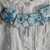 Collana in stoffa floreale sui toni del blu con perline di vetro a goccia e dettagli gialli e argentati