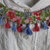 Collana colletto in stoffa floreale e nappine sui toni del rosso e dell'azzurro