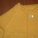 Completo per neonato composto da giacchino giallo e scarpine coordinate in pura lana vergine merinos. 