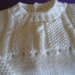 Completo bianco composto da  pantaloncino,  maglioncino e scarpine realizzato ai ferri in pura lana vergine