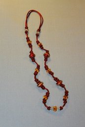 Collana realizzata a mano con nodi cinesi portafortuna e perle lampwork in vetro rosse