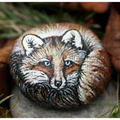 pietra di fiume dipinta con colori acrilici rappresenta una piccola volpe 