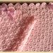 Copertina di lana rosa per passeggino o port-enfant lavorata all'uncinetto