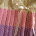 Maglioncino panna a righe rosa e lilla con fiocco di raso lavorato ai ferri per neonata