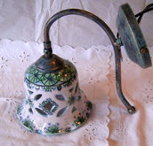 Applique-Lume campanella in ceramica con braccio in metallo anticato.