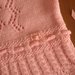 Elegante abito rosa per neonato con cuffietta coordinata realizzato ai ferri in lana merinos