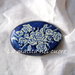Spilla ovale in legno rose perla su fondo blu dipinta a mano