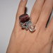 Anello regolabile di fili argentati "a molla" con perla porpora-uva e perla trasparente lucida