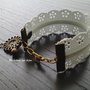 Bracciale cerniera effetto pizzo con bottone d'epoca in bronzo a forma di fiore e ciondolo a forma di streghetta