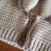 Scaldacuore beige con bordo nocciola e collo a scialle realizzato ai ferri in pura lana vergine
