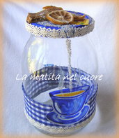 Barattolo di vetro con tazza blu dipinta, tovaglia, the, limone e zucchero