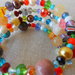 Bracciale memory a 4 giri con perle, perline, pietre dure  e cristalli di varie forme e colori.