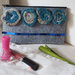 Astuccio portatrucco,penne, in feltro grigio chiaro.Applicate 4 rose tubolari (lana-cotone) gradazione beige-turchese-blu e paillettes blu