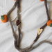 Collana AUTUNNALE in lana tubolare mélange beige.Applicazione ZUCCHE a crochet,cotone arancione e verde.Bottoni a forma di cuore in legno,uno chiaro ed uno scuro