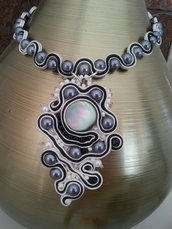 Collana elegante con le perline grige e bianche eseguita in tecnica soutache