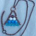 Collana con mezzi cristalli bianchi azzurri e viola con catena di rame