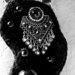 Collana con ciondolo di lana nero lavorata con il crochet .Vi è applicato un'orecchino una pallina nera e alcune perline nere (materiali di recupero).