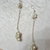 orecchini pendenti con nodi di perle di fiume e catenella argentata