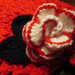Scaldacollo in lana rosso con fiore a uncinetto