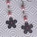 Orecchini pendenti con fiori traforati, perle e strass rosa e bianchi, fatti a mano