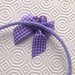 Cerchietto lilla all'uncinetto, con fiorellino viola e lilla con perline e fiocchetto a quadretti, fatto a mano