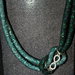 Collana in rete tubolare nera con cristalli swarovski verdi e simbolo dell'infinito