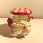 Piccolo barattolo per marmellate e composte con coperchio a quadretti bianco e rosso decorato con fiocchetti rossi lavorati all'uncinetto e nappine 