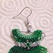 Orecchini pendenti con mini vestitini nelle sfumature del verde su piccola gruccia, decorati con perline e nastrini, fatti a mano all'uncinetto