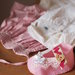 Scarpa/bimba in feltro rosa.Pizzo,passamaneria,raso,perla,bottone in legno (cuore).Decorazione ,bomboniera (nascita-battesimo).Idea Regalo