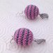 Orecchini pendenti con palline amigurumi a righe rosa e grigie, fatti a mano all'uncinetto, con ciondoli a foglia