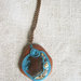 Collana con pendente in legno, vetro, cordoncino azzurro, sassolini e conchigliette.
