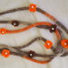 Collana in maglia tubolare.3 FILI.(lana-seta-cotone)Screziata:beige /marrone/arancione.9 Fiori a crochet con perle centrali.Accessorio di charme